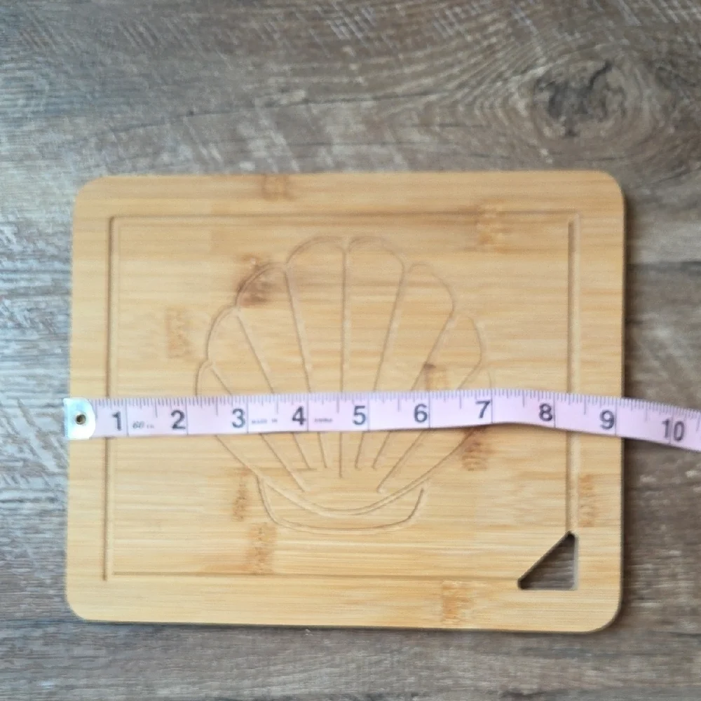 New Bamboo Cutting Board with Shell Design Carved In It